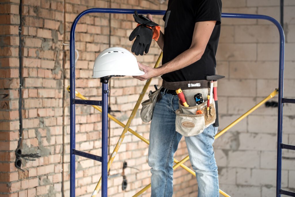 Builder handyman with construction tools. House and house renovation concept background.